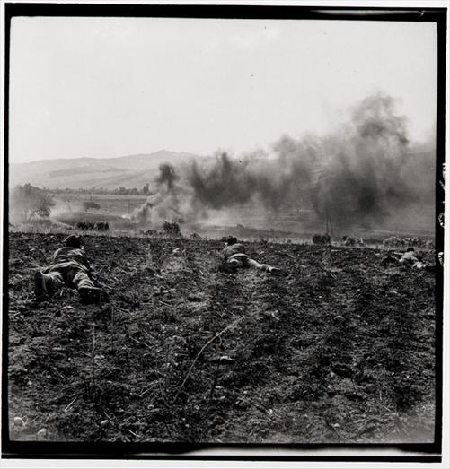 Canadian Light Infantry in action in Valguarnera, Sicily; Enemy trucks are ablaze in distance; 20 July, 1943.